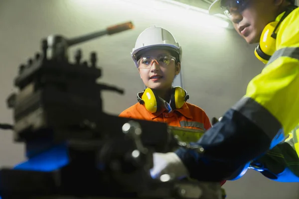 engineer cooperation Two asian maintenance engineers men and women inspect relay protection system with tablet device to control quality control process work a heavy industry manufacturing factory