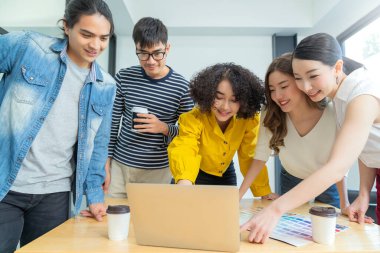 Dizüstü bilgisayardan elde edilen kârın başarıyla sonuçlandığı gizli toplantı sırasında dizüstü bilgisayar kullanan çok ırklı yaratıcı iş adamları grubu.