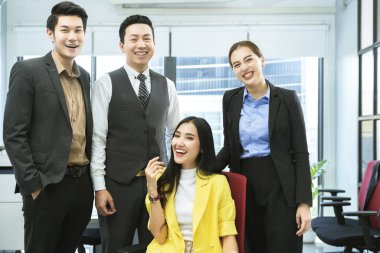 Asyalı iş adamlarının portresi modern tasarım ofisinin başarılı takım çalışması konseptine güler yüzlü güler.