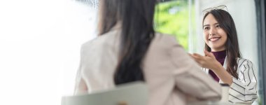 Asyalı kadın kreatif ajans gündelik toplantı tartışması ev müşterisi iş arkadaşı ile laptop kahve işi pencere ve su damlası yağmuru arka planda Asyalı genç kadın