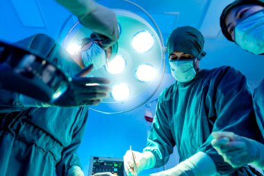 Bir grup Asyalı doktor ve hemşire ameliyathanede. Tıbbi ekip ameliyathanede ameliyat yapıyor. Tıbbi ekip kritik ameliyat yapıyor. Sağlık ve sağlık konsepti.