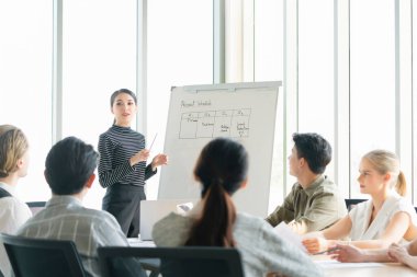 Genç Asyalı İş kadını lideri şirket satış stratejisi sunumunu modern ofis arka planında yapıyor.