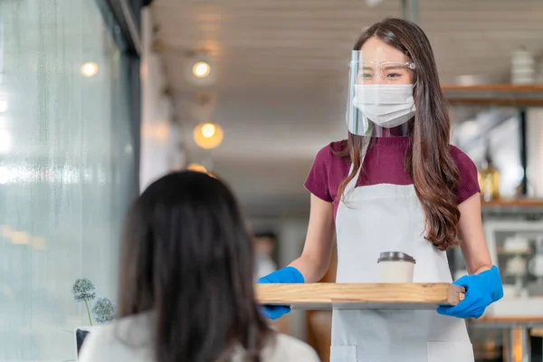매력적 아시아인 종업원들은 마스크와 장갑을 착용하고 고객들에게 커피를 — 스톡 사진