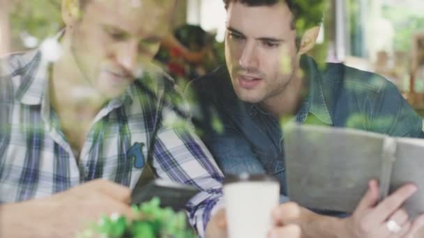 Dwóch partnerów biznesowych konsultować strategię biznesową ze szczęściem trzymać smartfona w tle kawiarni w pobliżu okna — Wideo stockowe