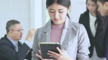 Asyalı akıllı iş kadını akıllı telefon ya da tablet cihaz iletişimi Asyalı iş arkadaşlarıyla iş görüşmeleri konseptinin arkasındaki tartışmadır.