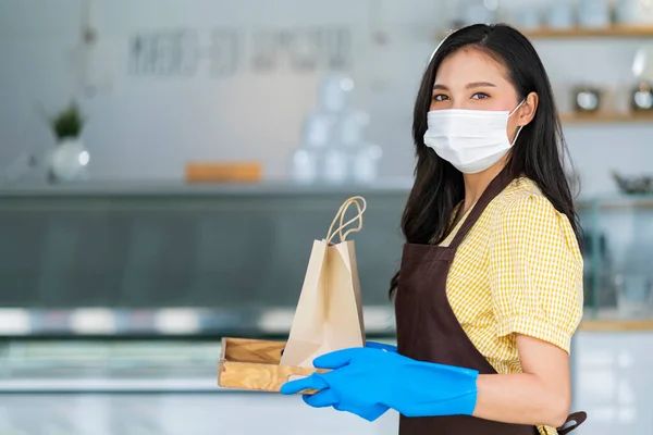 매력적 아시아인 종업원은 마스크와 장갑을 착용하고 고객에게 테이크 웨이트리스는 커피숍 — 스톡 사진