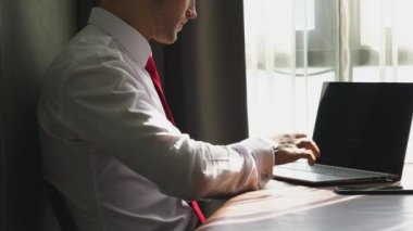 Akıllı Kafkasyalı iş adamı dikkatini dizüstü bilgisayara ve akıllı telefon ofis geçmişine ver.
