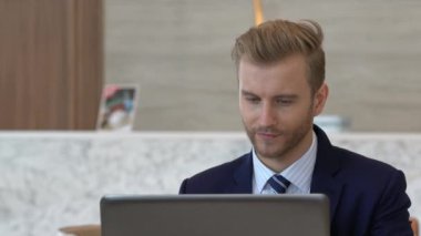 Takım elbiseli yakışıklı beyaz iş adamı laptopla iletişim ve akıllı telefon ofisi geçmişi.