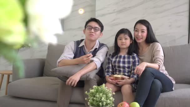 lassú mozgás ázsiai boldogság Család beszél és pihentető kanapén nézni TV együtt