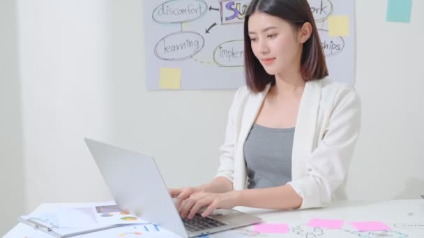 Erfolgreiche asiatische Business Offlce Frau arbeitet mit Laptop mit Glück und Frische Emotionen Büro Hintergrund — Stockvideo