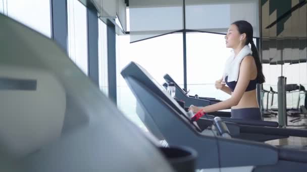 Powolny ruch piękne azjatyckie Sport kobiety spacer ostygnąć na bieżni cardio sprzęt siłownia tło — Wideo stockowe
