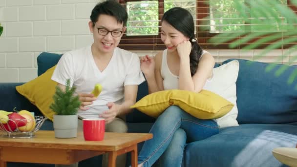 Lycka asiatiska par familj gifta njuta morgon samtal tillsammans med kärlek och relation på soffan med laptop och kaffe hem interiör bakgrund — Stockvideo