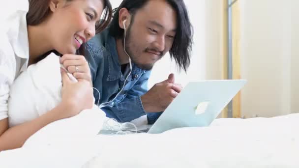 Lovley par gifta asiatisk familj njuta helg på sängen med bra film från laptop hem bakgrund — Stockvideo