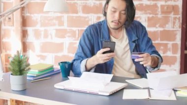 Zeki Asyalı erkek mimar mimari modeli ile çalışıyor. Malzeme seçiyor ve toplu model ev tasarımı kavramını inceliyor.