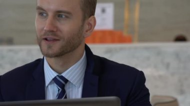Takım elbiseli yakışıklı beyaz iş adamı laptopla iletişim ve akıllı telefon ofisi geçmişi.