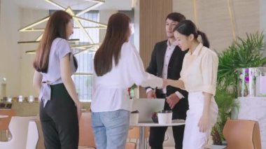 Zeki, neşeli Asyalı iş adamları modern ofis iç tasarım arka planında buluşmadan önce el sıkışmayı tanıtıyorlar.