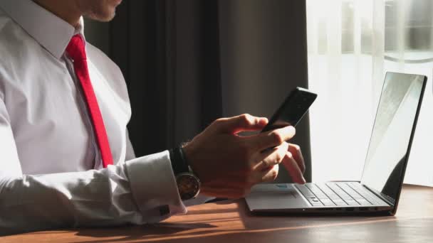Розумний білий бізнесмен зосереджується на роботі з ноутбуком та офісним фоном смартфона — стокове відео