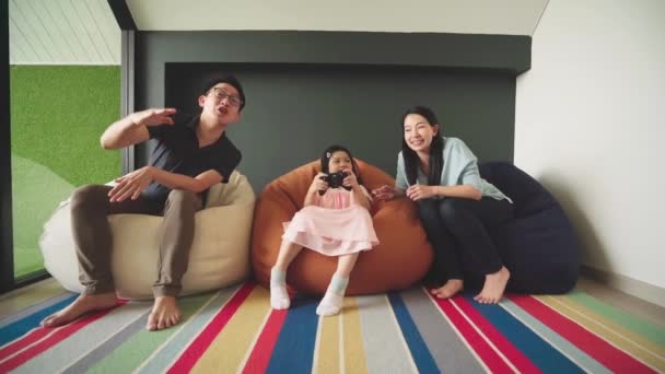 快乐快乐的亚洲家庭在家里一起玩电子游戏快乐的亚洲家庭在家里玩电子游戏快乐的亚洲家庭在家里玩电子游戏快乐的亚洲家庭在家里玩电子游戏快乐的亚洲家庭一起坐在沙发上笑 — 图库视频影像