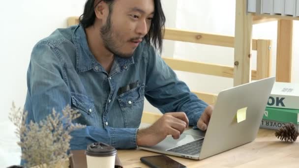 Yaratıcılık tasarımcısı Asyalı adam dizüstü bilgisayar ve kredi kartı geçmişi olan yeni bir proje üzerinde çalışıyor — Stok video
