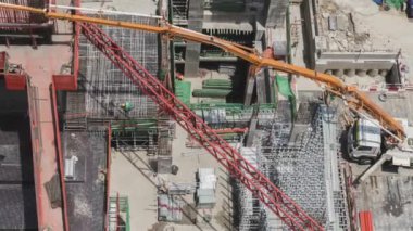 Çalışan inşaat sahasının havadan görüntüsünün 4k zamanlaması. İnşaat alanının yakınlaştırma görüntüsü üzerinde çalışan birkaç vinç de dahil olmak üzere büyük inşaat alanı.