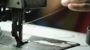 Deri fabrikasının arka planında dikiş makinesi üzerinde çalışan Terzinin Yakın Çekimi