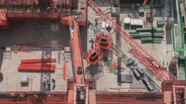 Çalışan inşaat sahasının havadan görüntüsünün 4k zamanlaması. İnşaat alanının yakınlaştırma görüntüsü üzerinde çalışan birkaç vinç de dahil olmak üzere büyük inşaat alanı.