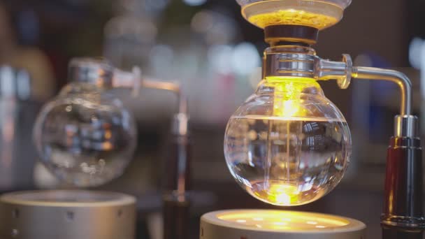 Syphon Koffiezetapparaat op gasfornuis proces wazig koffie shop achtergrond — Stockvideo