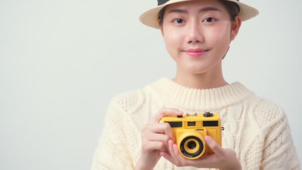 Atraktivní krásné asijské žena ležérní šaty nosit klobouk ruční držení film kamera cestování dovolená koncept bílé pozadí — Stock video