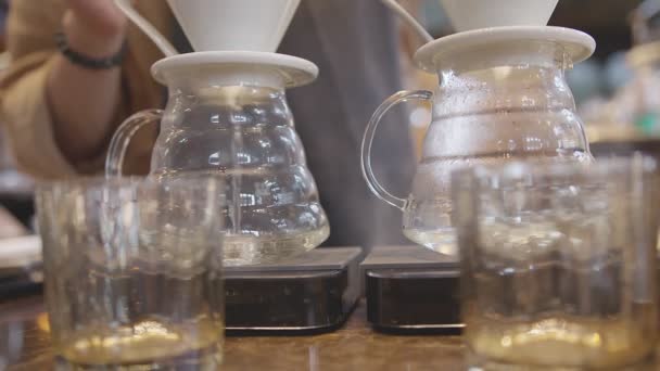 Barista bryggning kaffe närbild mannens hand barista gör drift kaffe med koncentrat och fokus med suddig coffeeshop bakgrund — Stockvideo