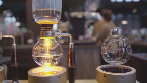 Syphon Koffiezetapparaat op gasfornuis proces wazig koffie shop achtergrond — Stockvideo