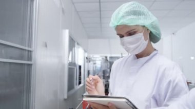 Cacasian kadın müfettişi içki fabrikasında içki üretim hattını teftiş ediyor. Fabrika fabrikası endüstriyel konseptinde içki ürünlerini kontrol ediyor.