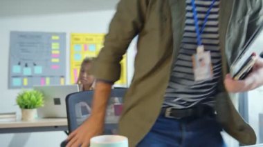 Beyaz erkek yaratıcı tasarımcı modern ofis iş yeri konseptinde kıdemli Kafkasyalı iş arkadaşıyla iletişimi gevşetiyor