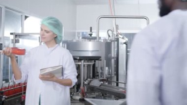Cacasian kadın müfettişi içki fabrikasında içki üretim hattını teftiş ediyor. Fabrika fabrikası endüstriyel konseptinde içki ürünlerini kontrol ediyor.