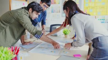 UX geliştiricisi ve UI tasarımcısının çalışma ortamında iş arkadaşı kısa ve renk kodlu bir masada mobil uygulama arayüzü iş akışı tasarımı hakkında beyin fırtınası yapmaları. Yaratıcı dijital geliştirme ajansı.