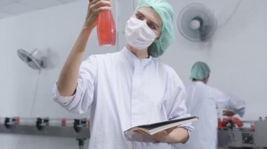 Cacasian kadın müfettişi içki fabrikasında içki üretim hattını teftiş ediyor. Fabrika fabrikası endüstriyel konseptinde içki ürünlerini kontrol ediyor.