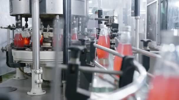 Aftapning af fabriksmaskiner produktionslinje rød juice aftapning linje til forarbejdning og aftapning saft i flasker. Selektiv fokus industriel teknologi forretningskoncept – Stock-video