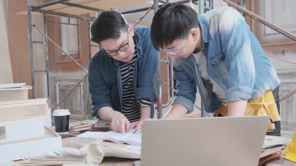 4kuhd智能男性亚洲室内设计人员咨询会议缓慢或机灵的蓝图、家庭模型和室内装修材料样品改造现场施工 — 图库视频影像