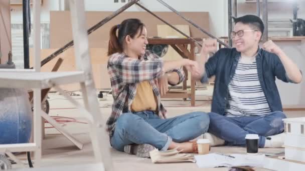 Vidám ázsiai pár kéz emelkedik fel danve együtt sikeres és boldog elégedettség felújítása a ház építési háttér — Stock videók