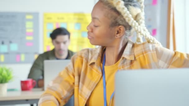 若い女性クリエイティブデザイナーは現代のスタートアップオフィスの職場コンセプトでシニアプログラマーの白人同僚とのコミュニケーションの会話をリラックス — ストック動画