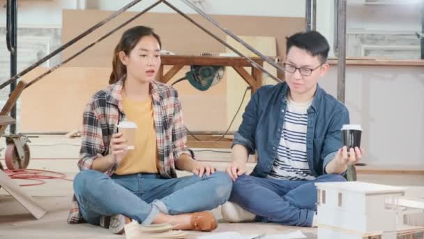 Fröhliches asiatisches Paar erhebt sich mit Erfolg und Glück bei der Renovierung der Hausbaustelle — Stockvideo