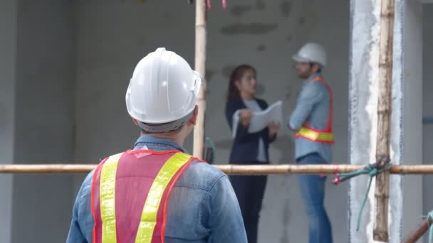 รูปภาพของการประชุมผู้จัดการวิศวกรเว็บไซต์หนุ่ม การตรวจสอบกับทีมงานวิศวกรในการก่อสร้างอาคารแนวคิดการปรับปรุงบ้าน — วีดีโอสต็อก