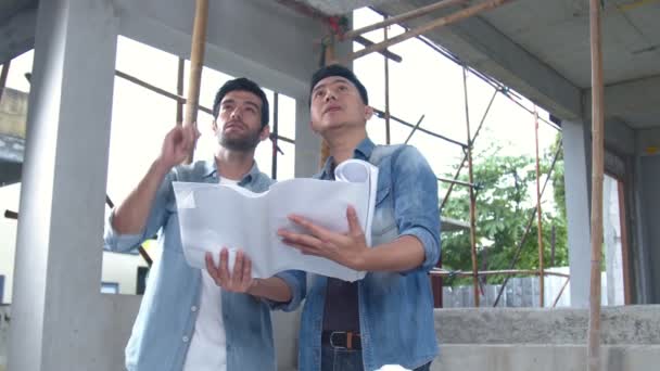 Цивільні інженери, інспектор та азіатський архітектор обговорюють, зустрічаються, інспектують та консультують щодо будівництва або реконструкції будинку з відбитком на будівельному майданчику. Інженерна концепція . — стокове відео
