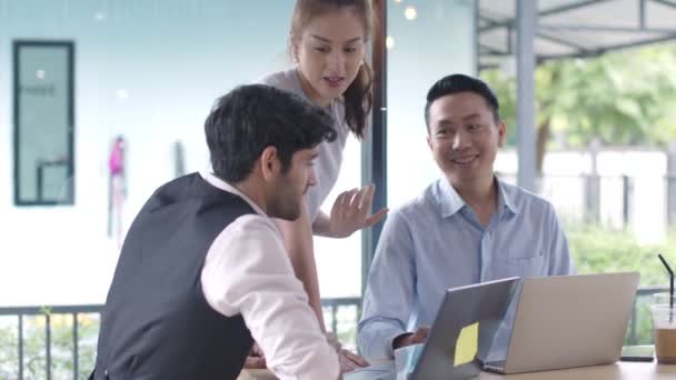 Üç Asyalı ve Kafkas iş adamı Laptop 'la kafeteryada yeni bir strateji çözümü bulma konusunda görüşüyorlar. — Stok video
