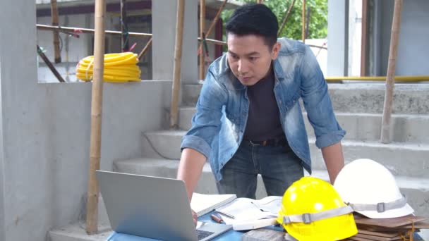 土木技術者 検査官 アジアの建築家は 建設現場の青写真を持つ家の建物や改修プロジェクトについて話し合い 助言を行います 工学の概念 — ストック動画