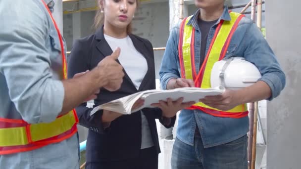 Jovens engenheiros asiáticos e colegas de engenharia caucasianos no inspetor do local e discutir juntos usando notebook computador e papel planta no edifício conceito de ideias de renovação site.home — Vídeo de Stock