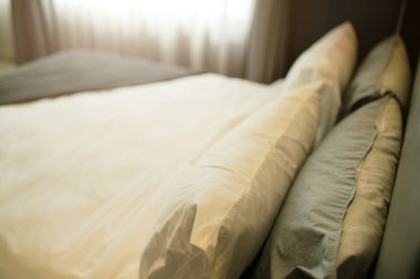 Güzellik odasında temiz beyaz yastıkları ve çarşafları olan yatak hizmetçisi. Yakın plan. Güneş ışığı altında mercek..