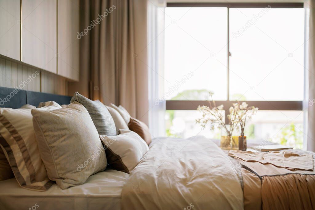 Bed maid-up with clean white pillows and bed sheets in beauty room. Close-up. Lens flair in sunlight.