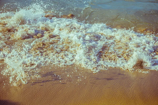 Ola de espuma de mar en la playa de arena — Foto de Stock