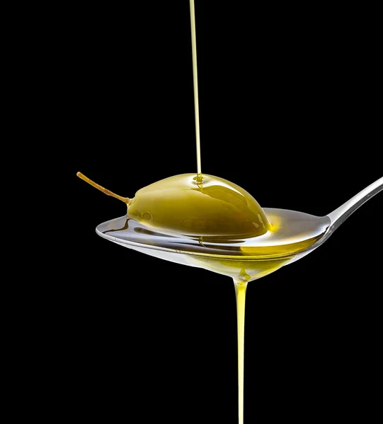 Green olive in full oil spoon on black isolated — Stock Photo, Image