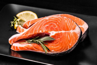 Two slices of salmon steak with lemon clipart